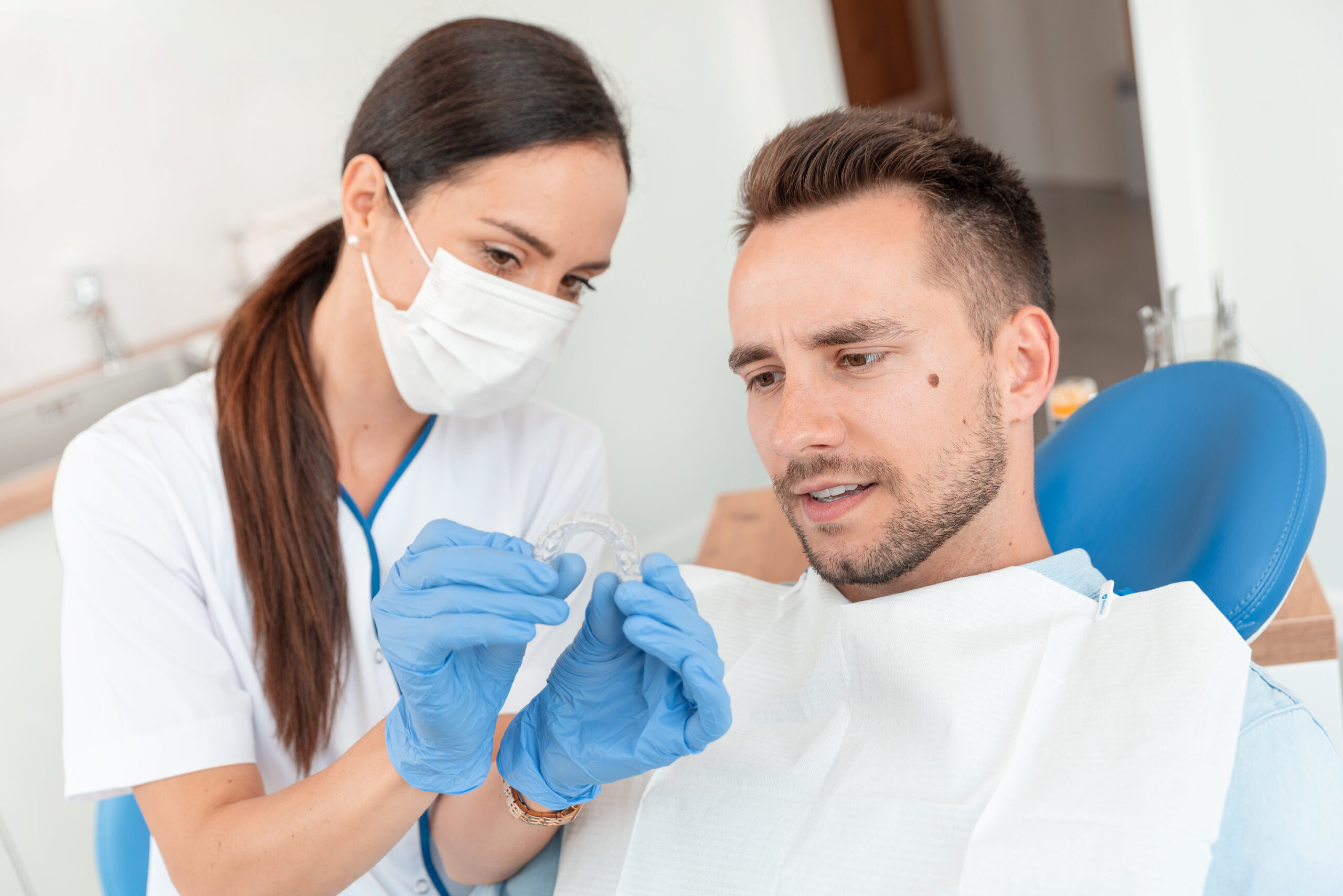 歯科医院で患者にインビザラインを見せる歯科医師