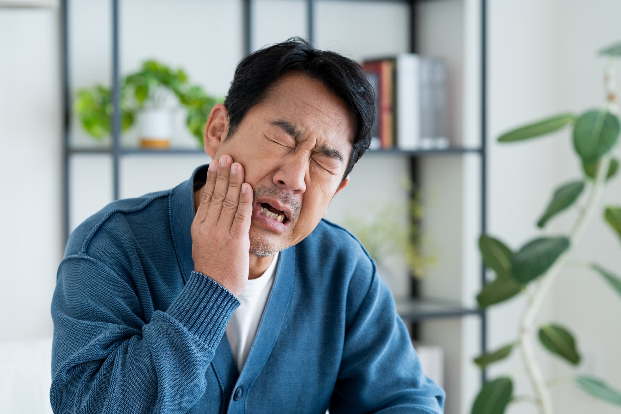 インプラント治療後の痛みで顔をしかめる男性