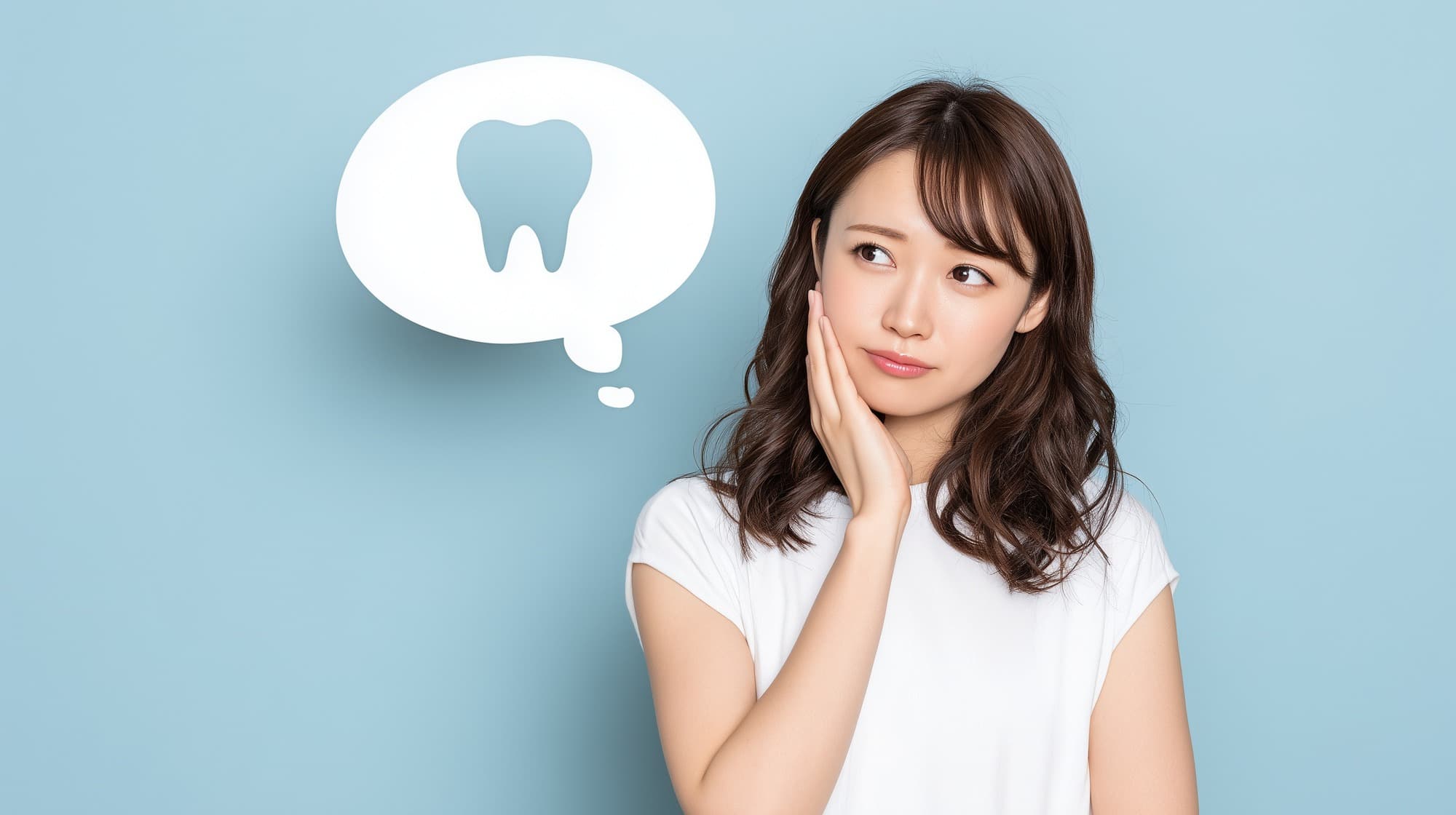 横向きに生えた親知らずは抜くべきなのか考える女性