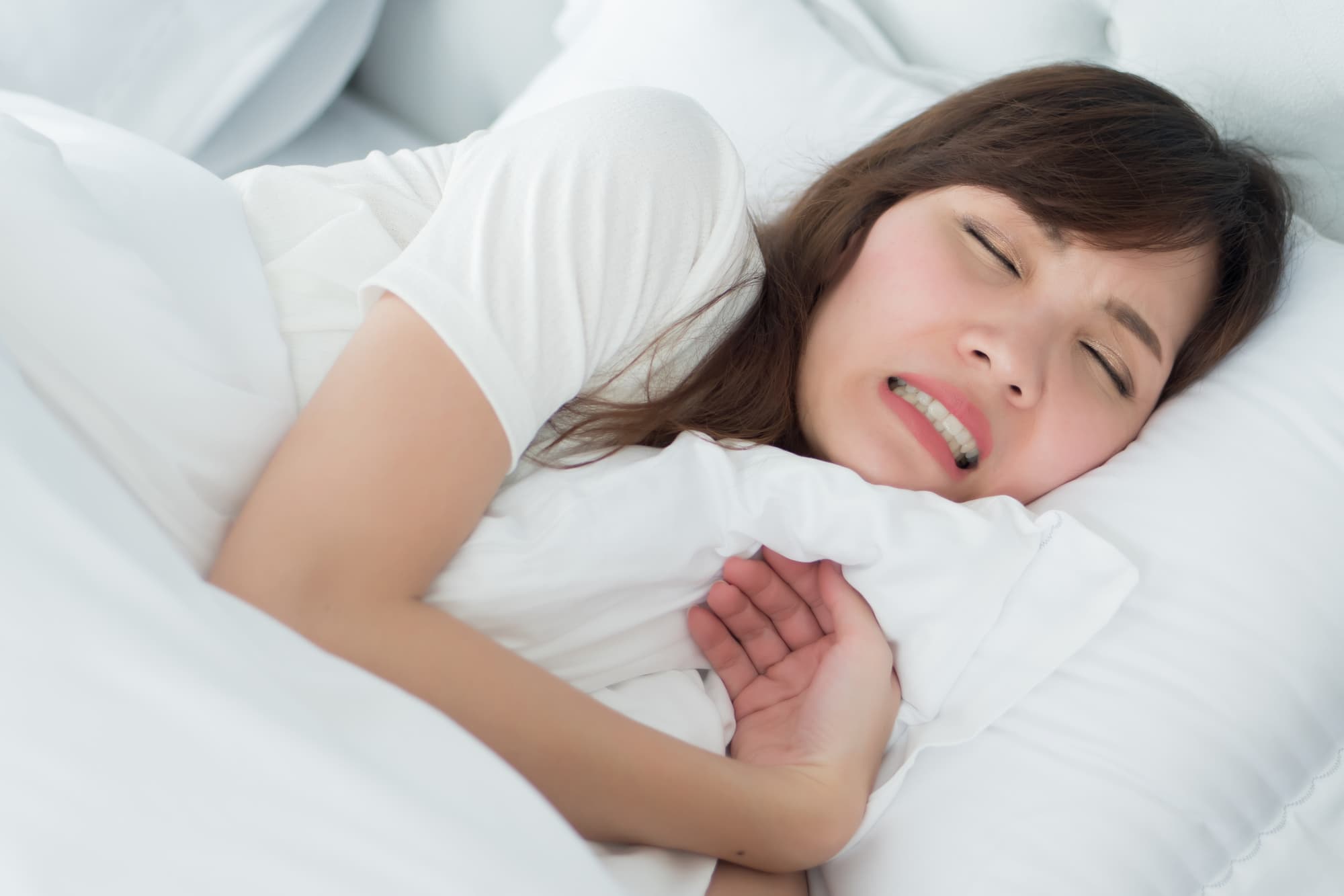 睡眠中に歯ぎしりをする女性