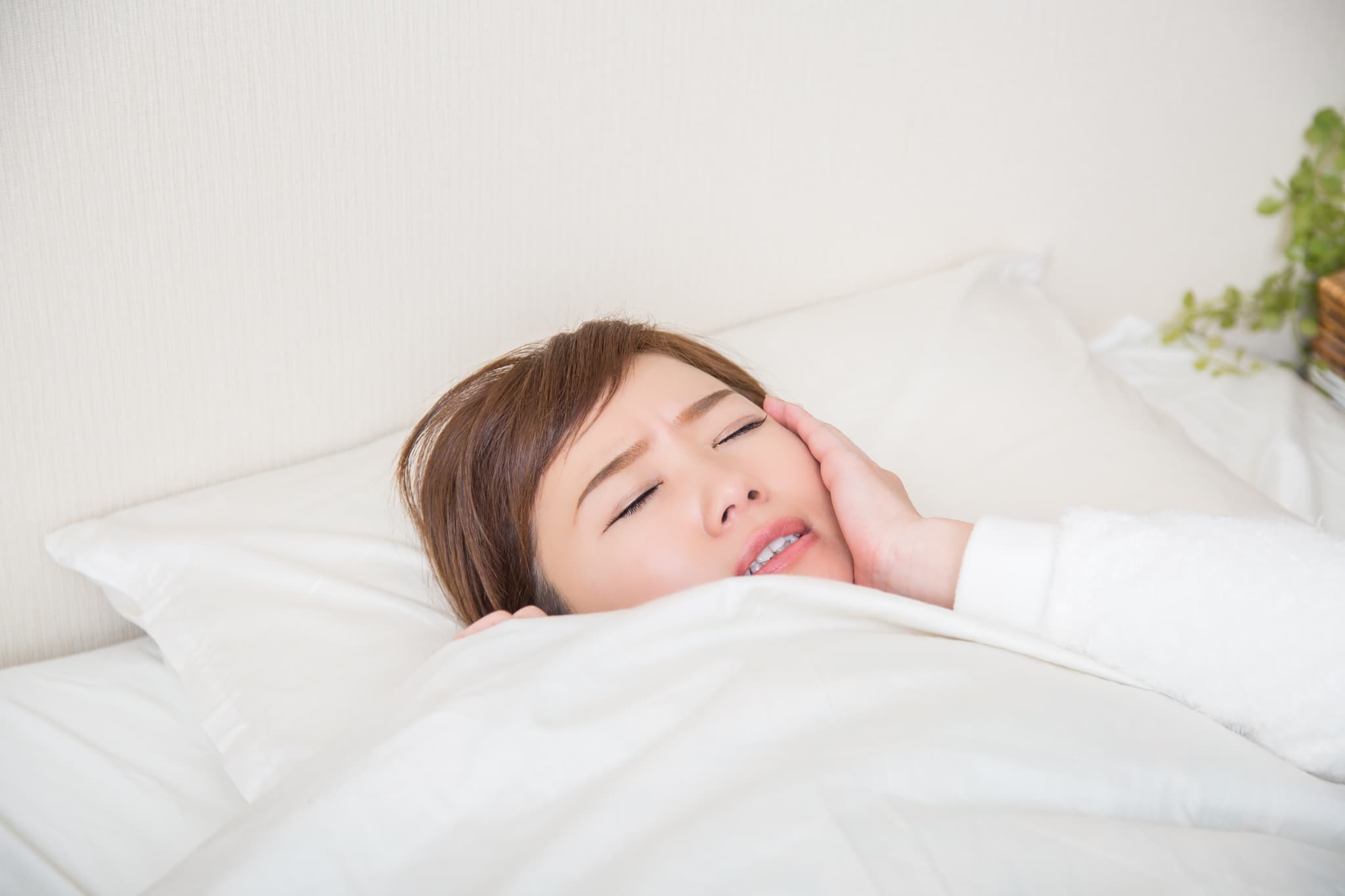 親知らずの虫歯を放置したために痛みで眠れない女性