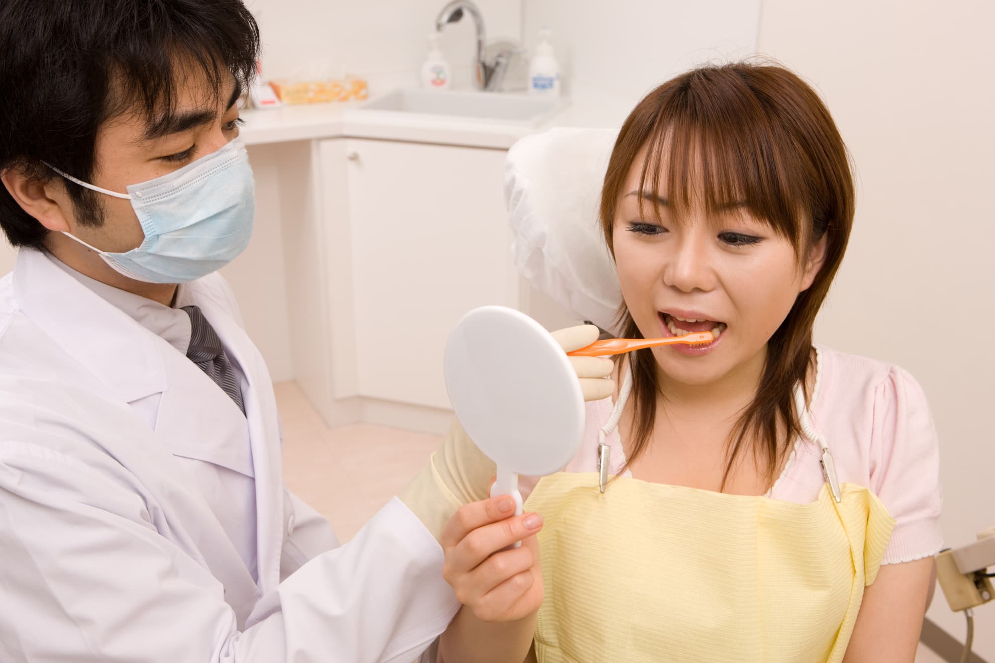 歯科医からブラッシング指導を受ける女性
